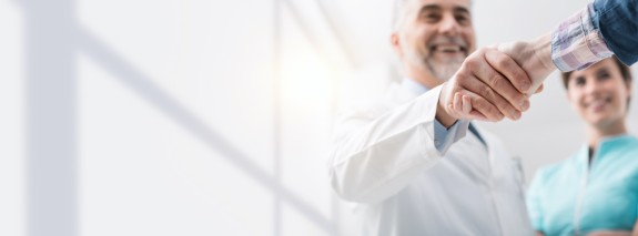 Zahnarzt und Patient schütteln sich die Hände